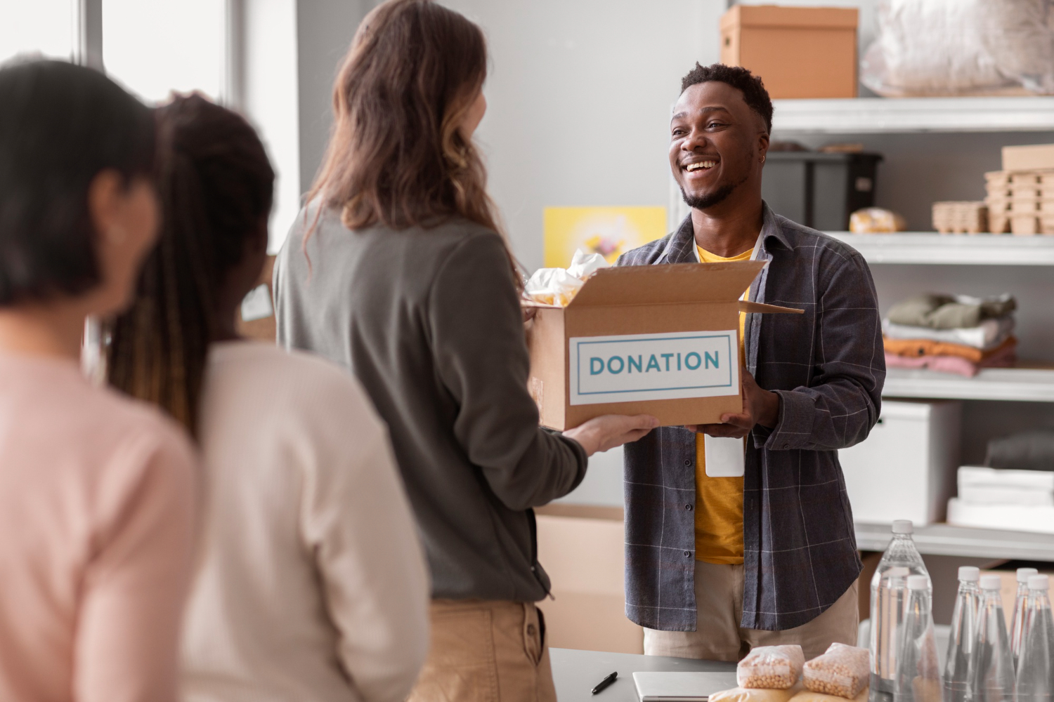 woman donating a box of items handing it to man 